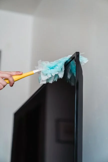 who-we-are A person in full PPE disinfecting a table indoors for hygiene and safety.